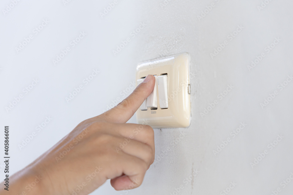 Close up young man's hand pressed the button to turn on the light switch, Open the electrical circuit beside the wall. Close up young man's hand pressed the button to turn on the light switch, Open the electrical circuit beside the wall.
