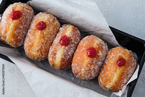 Traditional German Polish Donut with Raspberry Jam Dusted with Sugar. The traditional meal on Fat Thursday, the last day of the carnival.