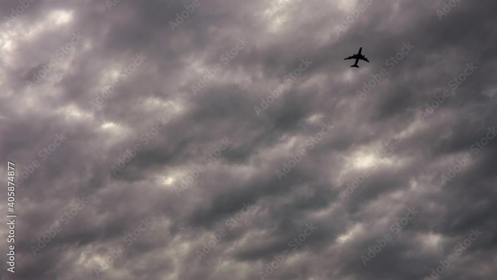 Dramatic view of cloudy sky and plane flying in sky. Bad weather conditions. Dramatic view of cloudy sky and plane flying in sky. Bad weather conditions.