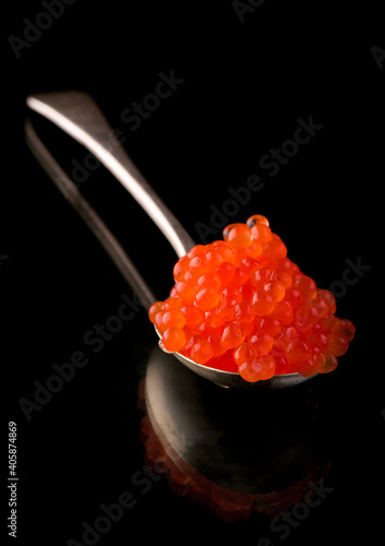 Red Caviar in a spoon over black background. Close-up salmon caviar. Delicatessen. Gourmet food. Texture of caviar. Seafood