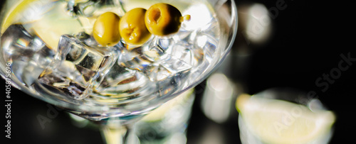Tableau sur toile Traditional drink based on gin and vermouth with olives and ice cubes in a cockt