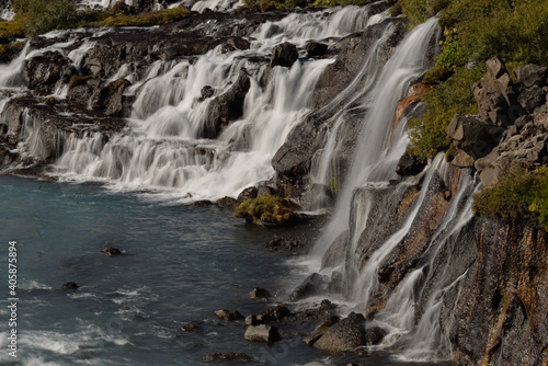 Hraunfossar waterfalls cascading into the Hv  t   river over ledges of lava rock