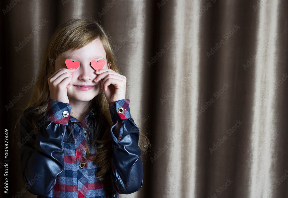 The girl closes her eyes with red hearts. Valentine's Day.