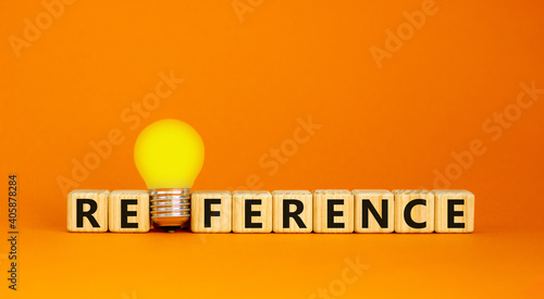 Reference symbol. Wooden cubes with the word 'reference'. Yellow light bulb. Beautiful orange background. Business and reference concept. Copy space.