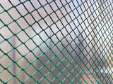 Fence from the grid with green polymer coating. cage green background
