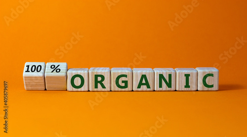 100 percent organic symbol. Fliped wooden cubes and changed words 'organic' to '100 percent organic'. Beautiful orange background, copy space. Business, healthy lifestyle organic concept.