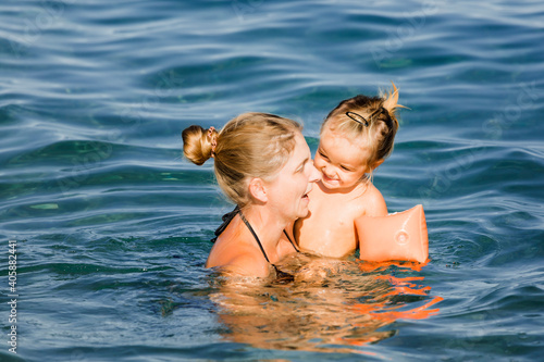 Mother with toddler girl in sea