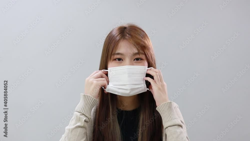 Isolated Asian girl wearing mask and remove mask Isolated Asian girl wearing mask and remove mask