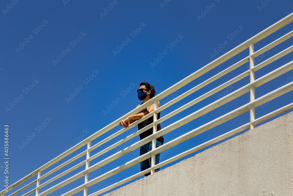 Homem jovem, apoiado em parapeito de metal em rampa de acesso em um parque na cidade de Goiânia. Homem jovem, apoiado em parapeito de metal em rampa de acesso em um parque na cidade de Goiânia.