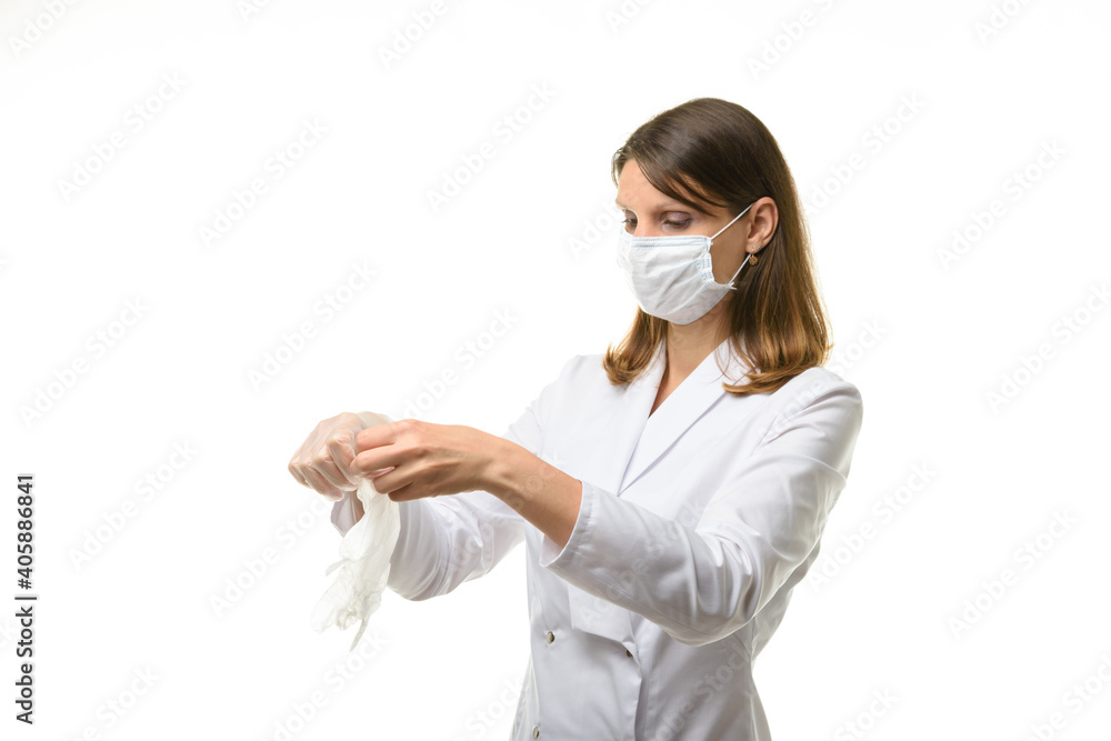 Girl doctor unfolds medical gloves before putting them on Girl doctor unfolds medical gloves before putting them on