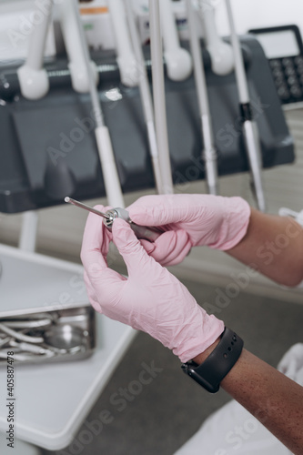 the dentist holds a medical instrument in his hand