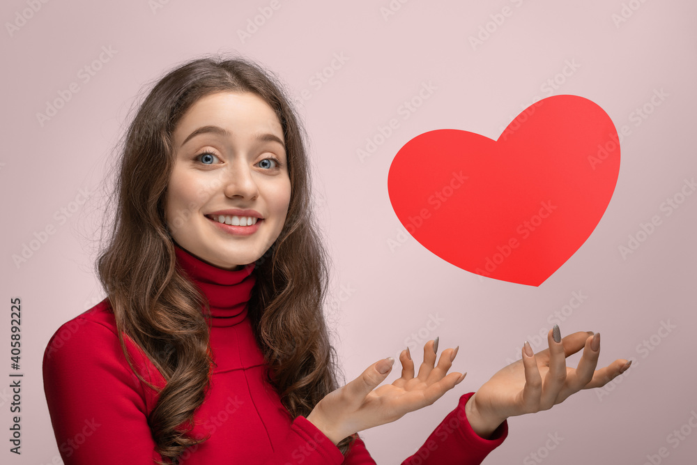 Girl with red cardboard heart, heart hanging in the air Girl with red cardboard heart, heart hanging in the air