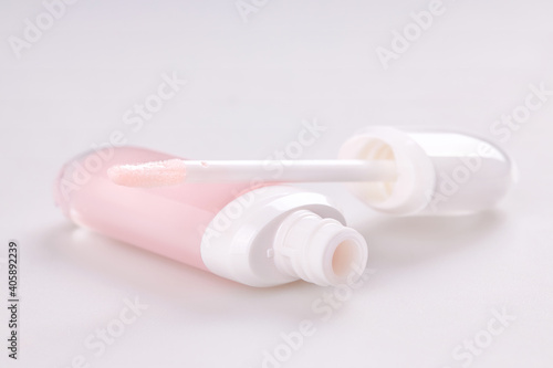 Tube of liquid lipstick gloss with applicator isolated on white background