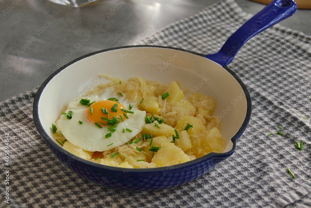 Mashed potatoes with sauerkraut, fried egg and chives in pan Mashed potatoes with sauerkraut, fried egg and chives in pan