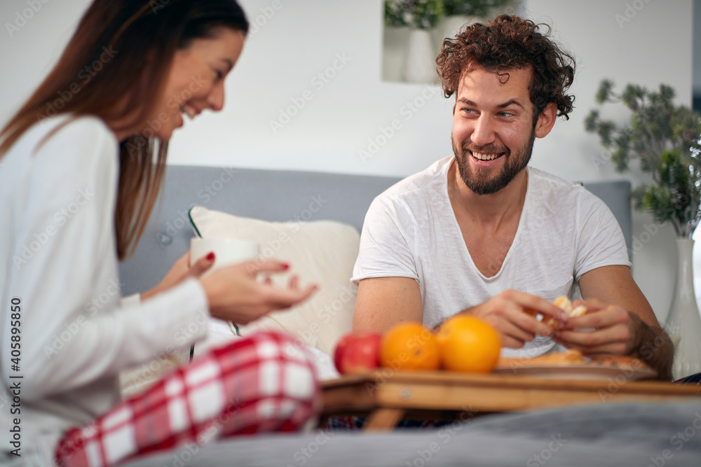 A young couple having a good time while having a breakfast in the bed. Love, relationship, together A young couple having a good time while having a breakfast in the bed. Love, relationship, together