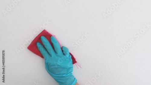 Employee's hands were wiping the white walls, use a towel moistened with cleaning solution to rub the wall, Text fill area, White background, Eliminate germs during the virus outbreak, 4K Footage.