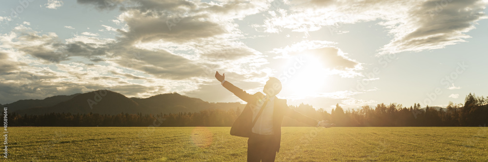 Young businessman celebrating life outside lit by the sun Young businessman celebrating life outside lit by the sun