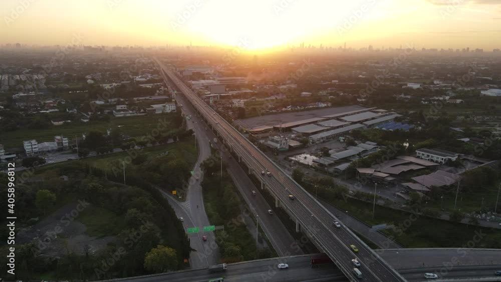 4K. Aerial view of road interchange or highway intersection during sunrise with busy urban traffic speeding on the road. Junction network of transportation taken by drone. 4K. Aerial view of road interchange or highway intersection during sunrise with busy urban traffic speeding on the road. Junction network of transportation taken by drone.