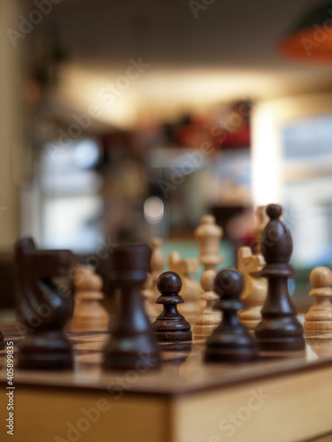 wooden chessboard with the chess pawn in focus and a blurred background