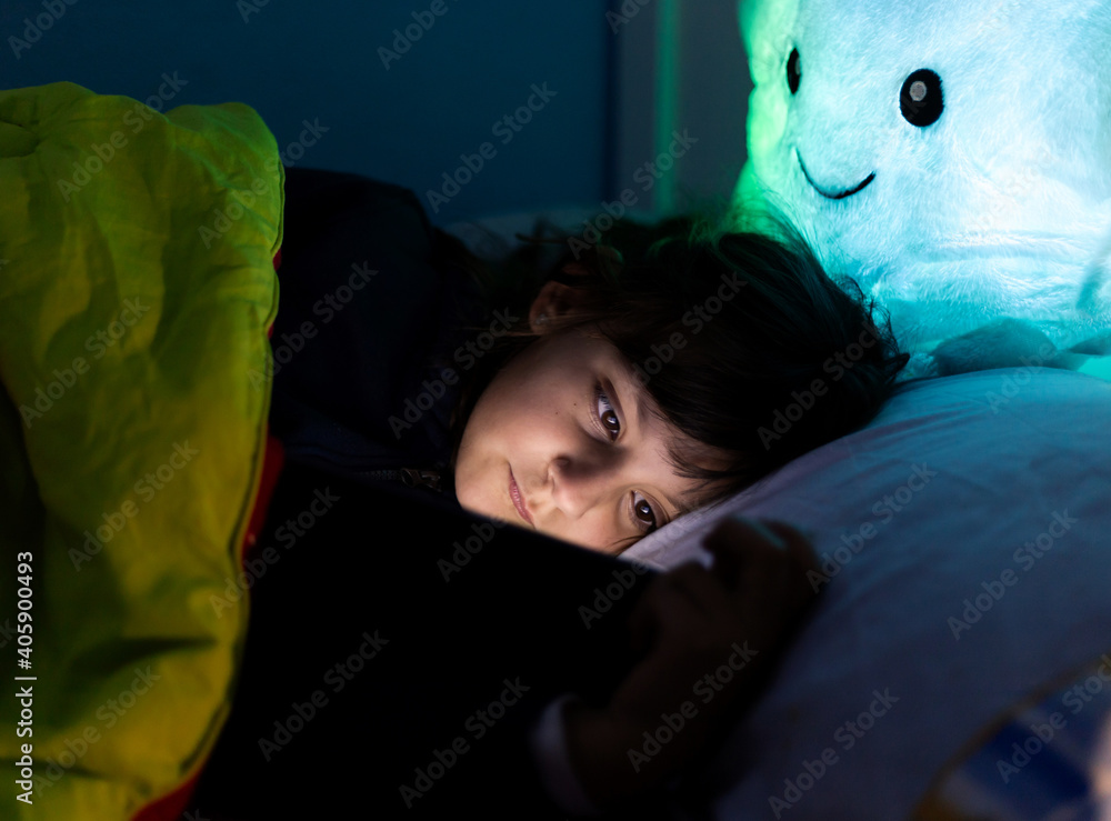 little caucasian girl, watching the Tablet, in bed before bed little caucasian girl, watching the Tablet, in bed before bed