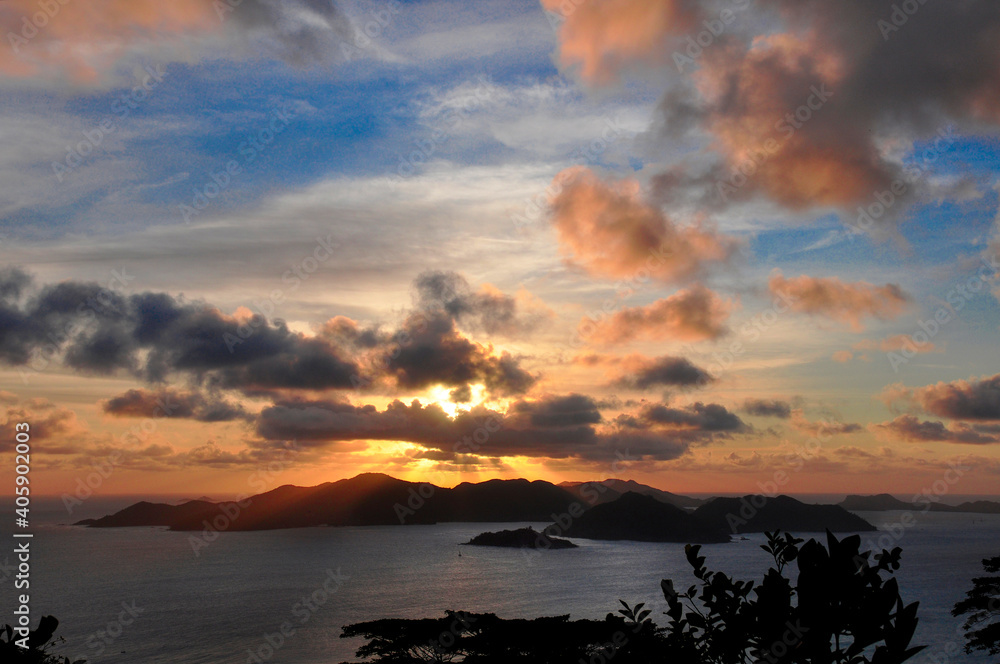 High angle view of the sunset over the island of Praslin with vibrant sky and the ocean with reflections