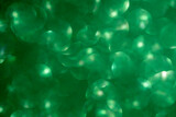 Green glitter vintage lights background. Defocused. Close-up