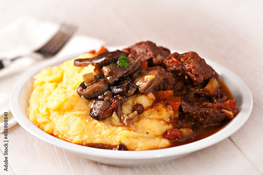 Delicious beef stew with mushrooms and polenta. High quality photo Delicious beef stew with mushrooms and polenta. High quality photo
