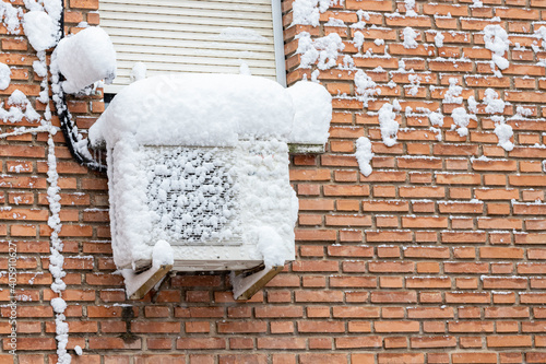 snow covered air conditioning outdoor unit