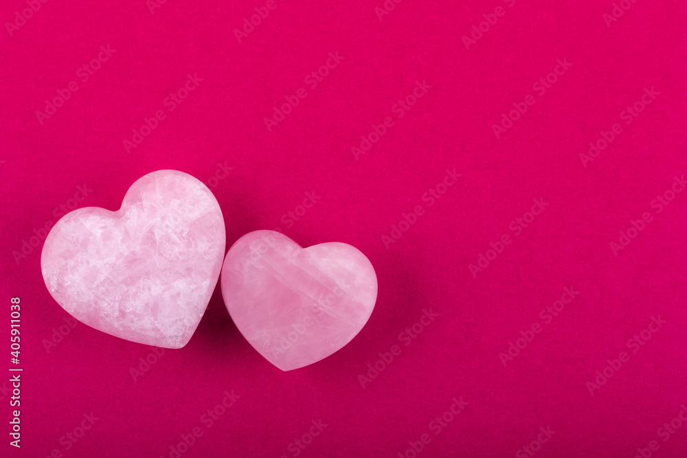 Two quartz hearts on fuchsia background. Concept Valentine's day. Concept Mother's day. Free copy space