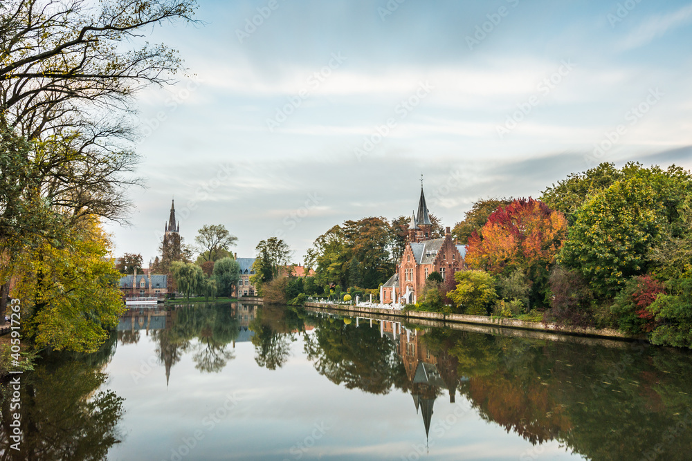 Autumn mood by the Minnewater (Lake of love) in Bruges.  Bruggy Belgium Minnewater. A historic church by the water.