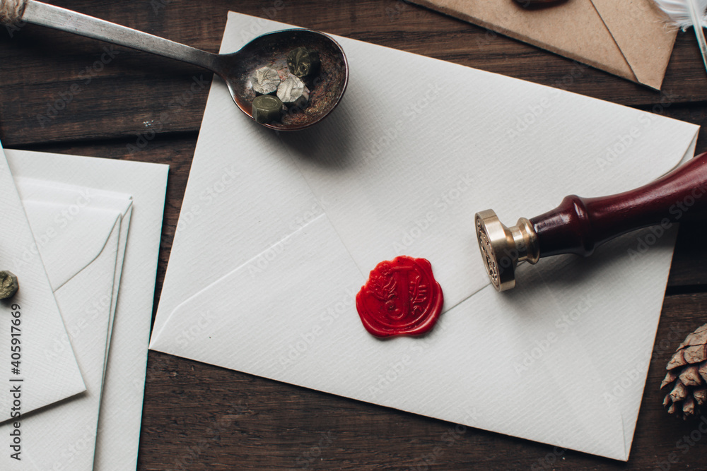 Letter seal with wax seal stamp on the wood table. Vintage notary stamp and sealed  envelope. Post concept. Sealing wax. Wax seal. Dark academia style.  Scandinavian hygge styled composition. Stock Photo