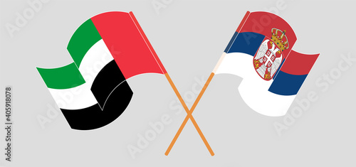 Crossed and waving flags of the United Arab Emirates and Serbia