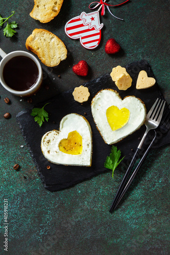 Breakfast on Valentines Day or brunch. Heart shape fried egg on slate plate. Top view flat lay. Free space for your text.