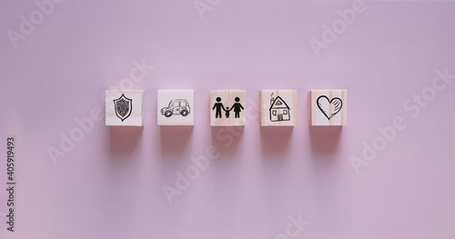 Insurance concept. Wooden blocks with insurance icons. family  life  car  travel  health and house insurance icons. blue background with copy space
