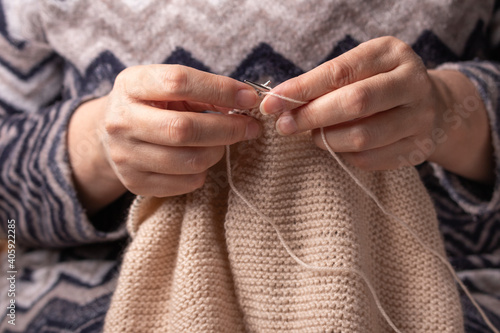 woman hands knitting wool yarn with knitting needles	