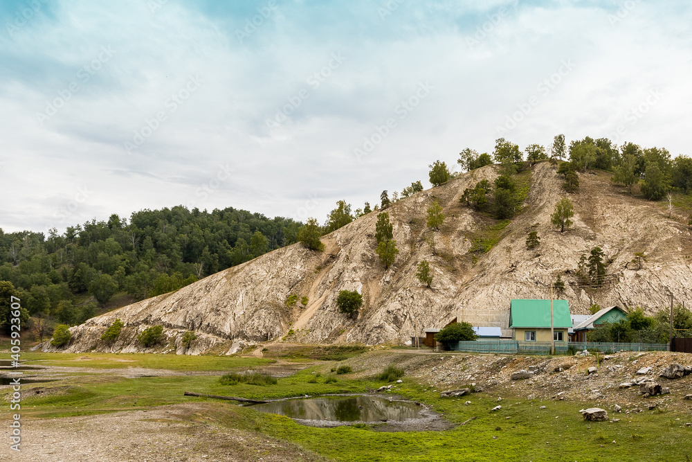 Scenery landscape with green forest and high rocky mountain under blue sky. rural landscape Scenery landscape with green forest and high rocky mountain under blue sky. rural landscape