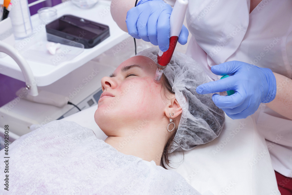 The girl at the reception at the beautician. The process of mesotarpia with the introduction of serum under the skin The girl at the reception at the beautician. The process of mesotarpia with the introduction of serum under the skin