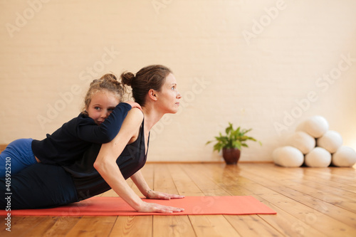 Mother and daughter exercing together in a yoga studio photo