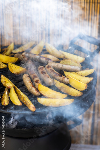 charcoal garden grill with potatoes and sausages