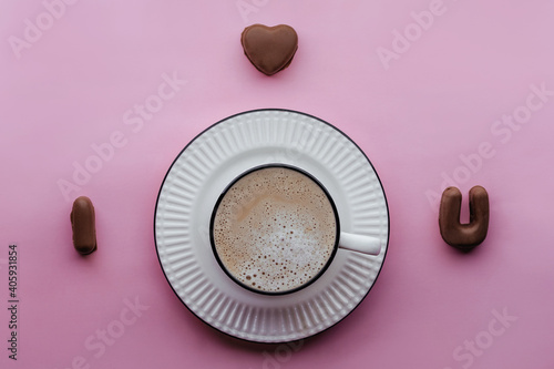 handmade chocolate candies and coffee on pink backdrop, i love you shape confectionery mold. concept for Valentine's Day, wedding, anniversary, Love symbol.