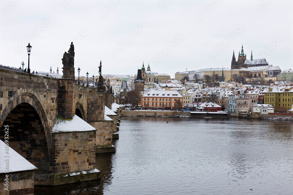 Snowy Prague Lesser Town with Prague Castle and Charles Bridge above River Vltava, Czech republic