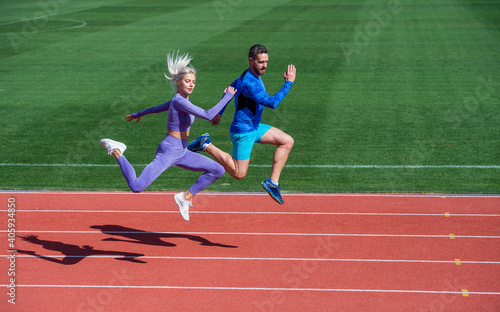 energy stamina. fit sporty people jumping. man and woman sport trainer run. fitness couple training outdoor. runners on running track. challenge and competition. endurance