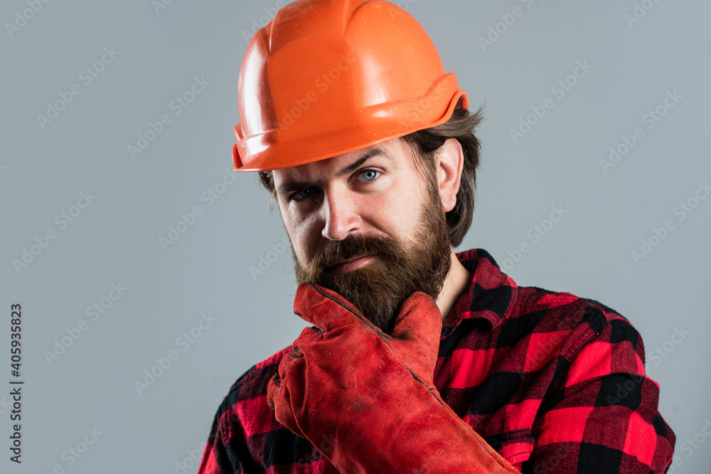 bearded male hipster in checkered shirt and laborer helmet, mechanic bearded male hipster in checkered shirt and laborer helmet, mechanic
