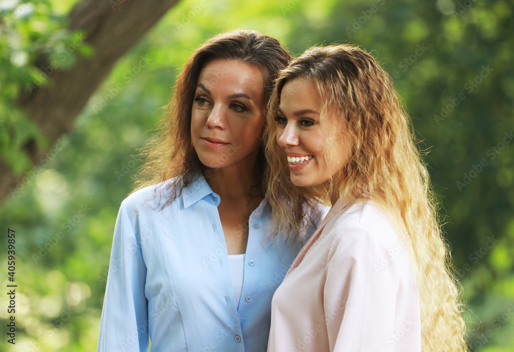 lifestyle and people concept: mature mother and adult daughter hugging in the park lifestyle and people concept: mature mother and adult daughter hugging in the park