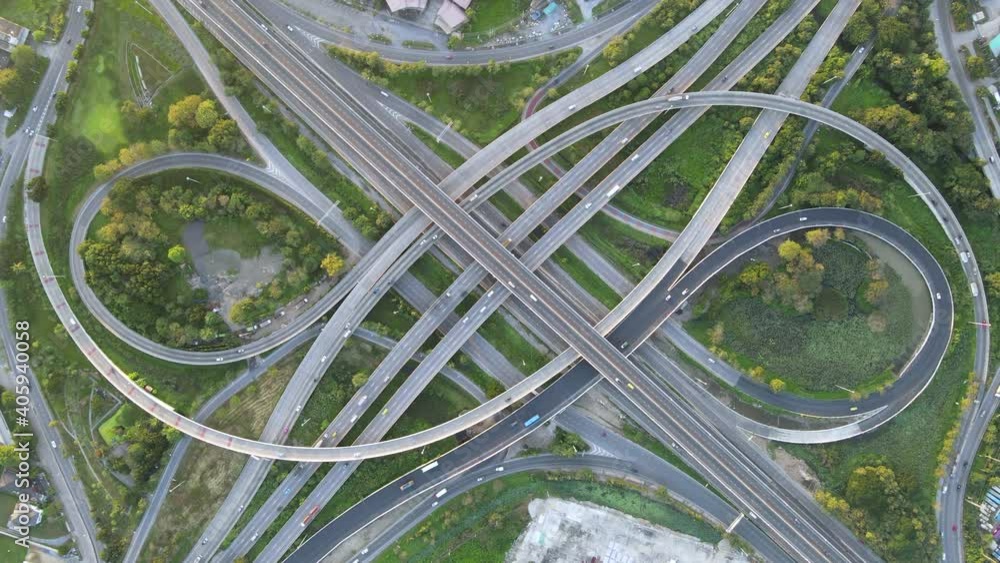 4K. Aerial view of road interchange or highway intersection with busy urban traffic speeding on the road. Junction network of transportation taken by drone. 4K. Aerial view of road interchange or highway intersection with busy urban traffic speeding on the road. Junction network of transportation taken by drone.