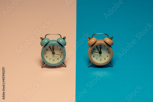 Pastel colors retro clocks that show five minutes to twelve. Dual color background