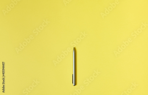 Flat lay. Top view of a grey pen isolated on a yellow background. Coppy space