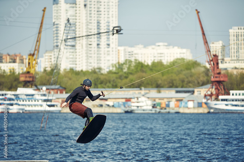 Young man riding wakeboard on a summer lake