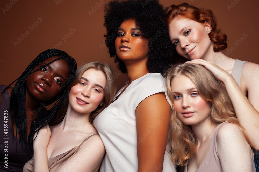 Obraz premium young pretty caucasian, afro, scandinavian woman posing cheerful together on brown background, lifestyle diverse nationality people concept