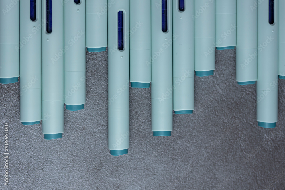 Press point backs of syringe self application pens against a rustic textured gray background. Studio medical equipment still life concept with auto-injector disposable devices. Press point backs of syringe self application pens against a rustic textured gray background. Studio medical equipment still life concept with auto-injector disposable devices.